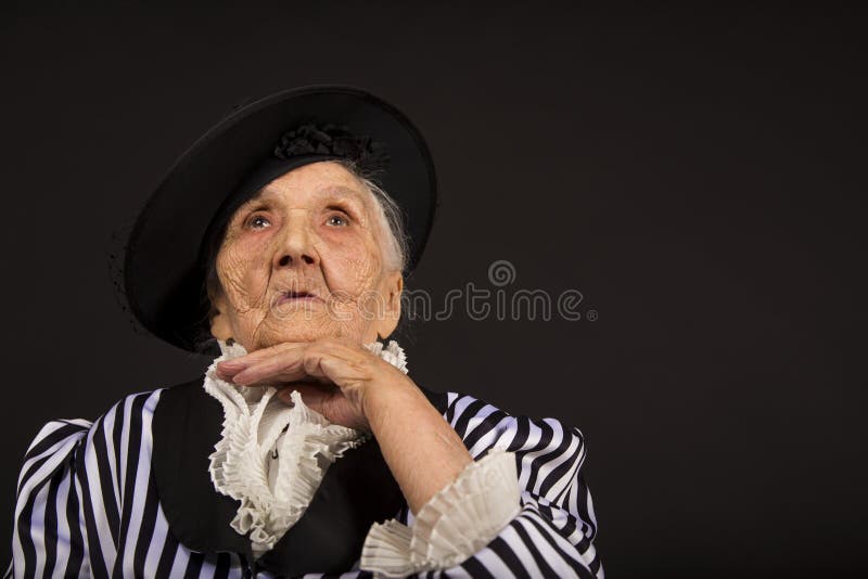 Παλαιό grandma σε ένα άσπρος-μαύρο ριγωτό σακάκι στοκ φωτογραφίες με δικαίωμα ελεύθερης χρήσης